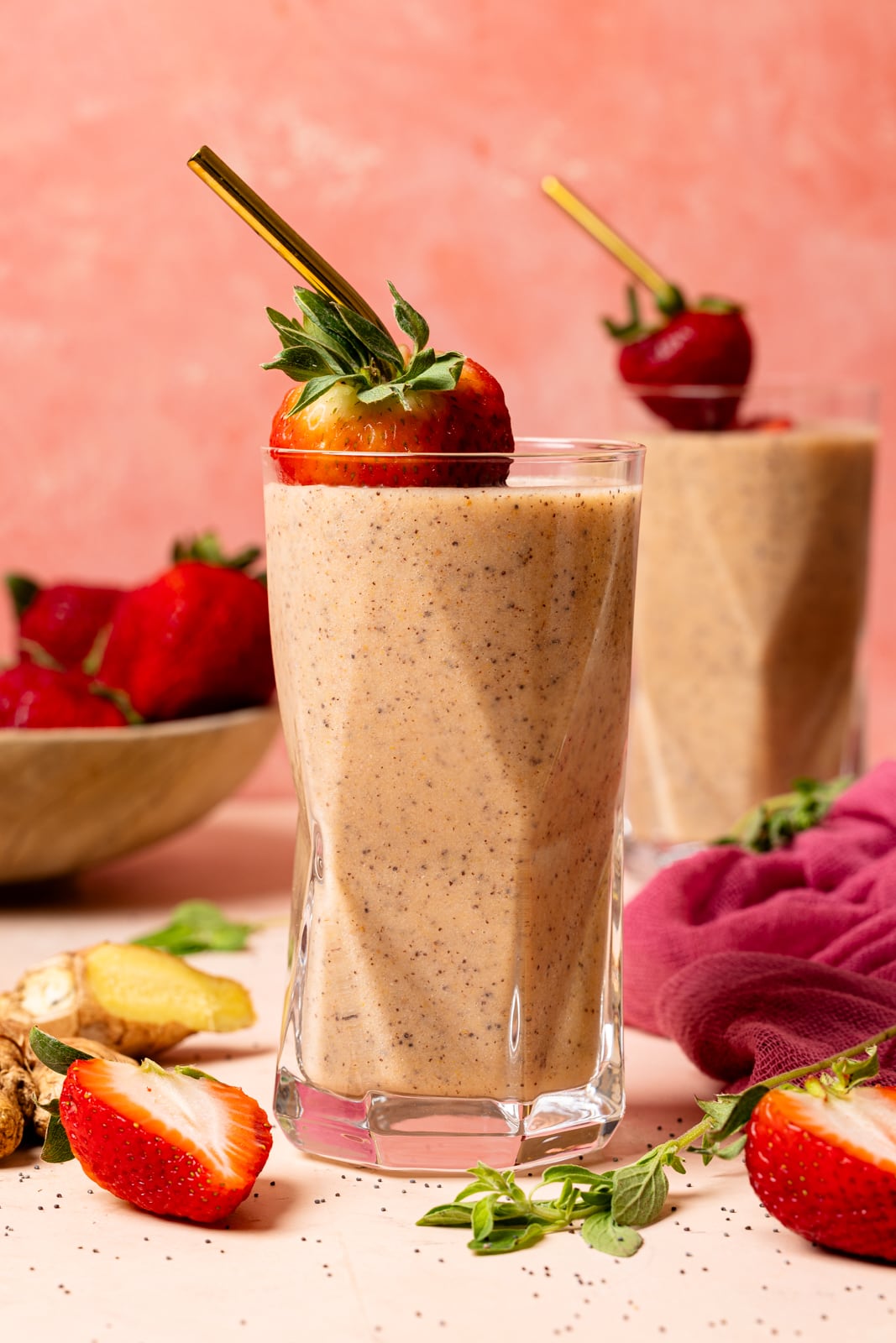 Two glasses on smoothies with fresh strawberries.