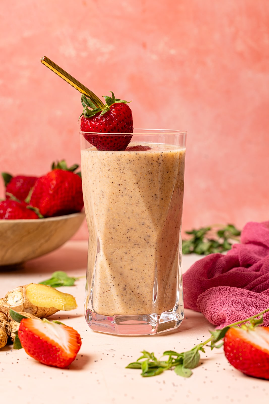 One glass of smoothie with fresh strawberries, ginger, and herbs.