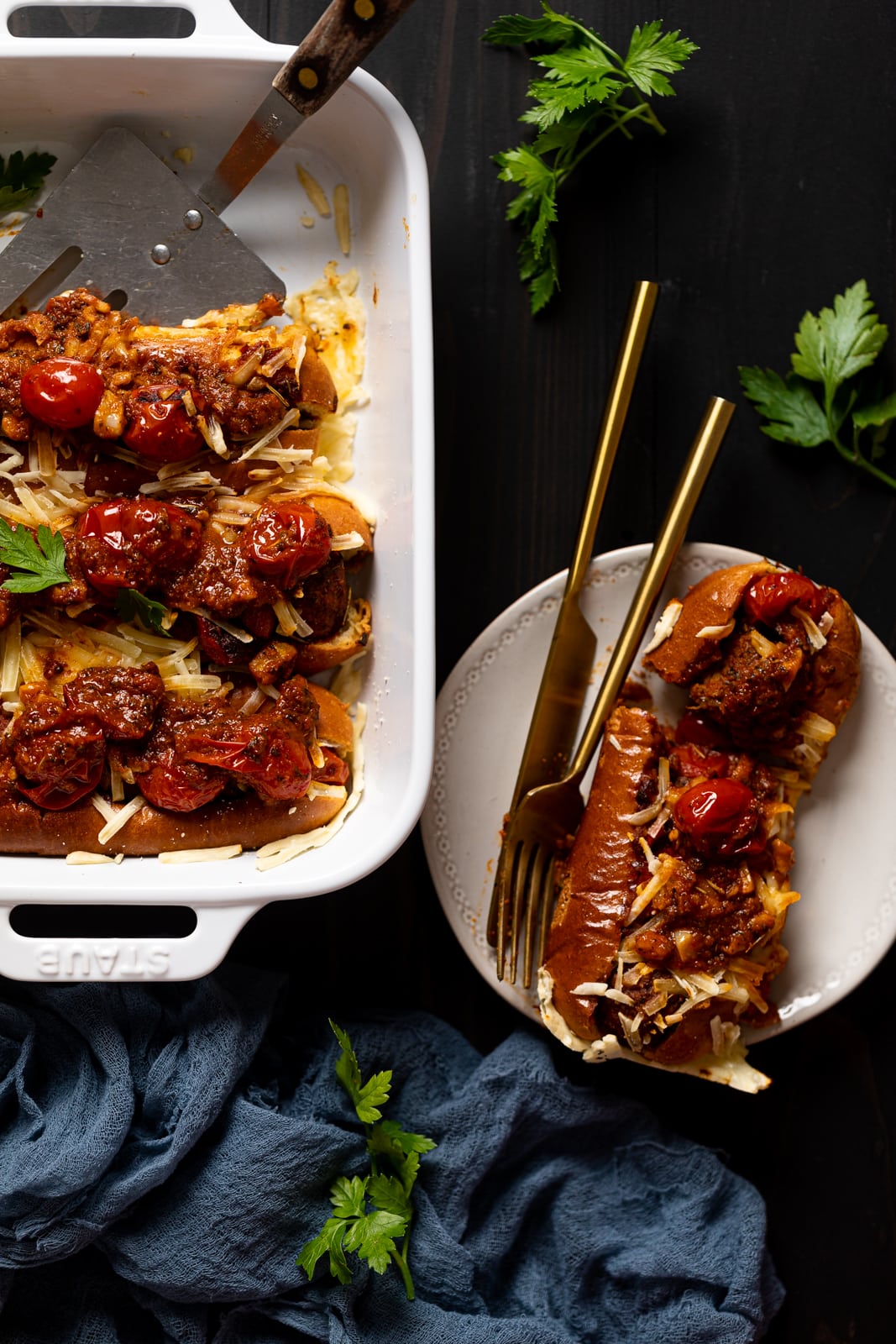 Vegan Meatball Sub on a plate next to a pan of vegan meatball subs