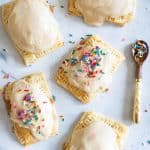 Vegan Apple-Cinnamon Pop Tarts on a table with a spoon of sprinkles.