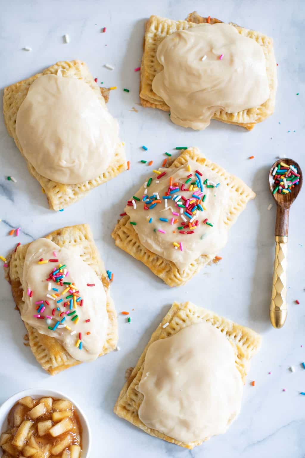 Vegan Apple-Cinnamon Pop Tarts on a marbled surface with a spoon.