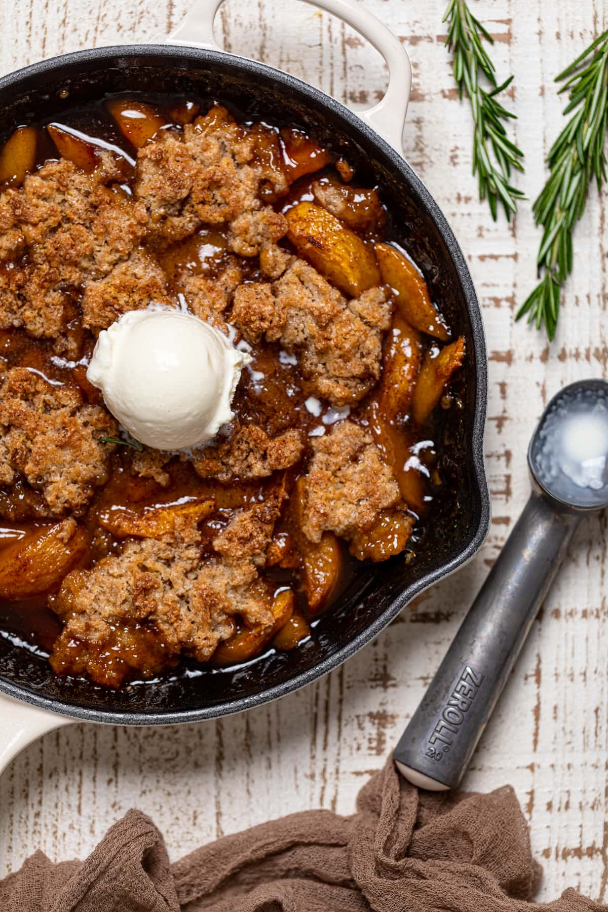 Vegan Southern Peach Cobbler topped with a scoop of dairy-free ice cream.