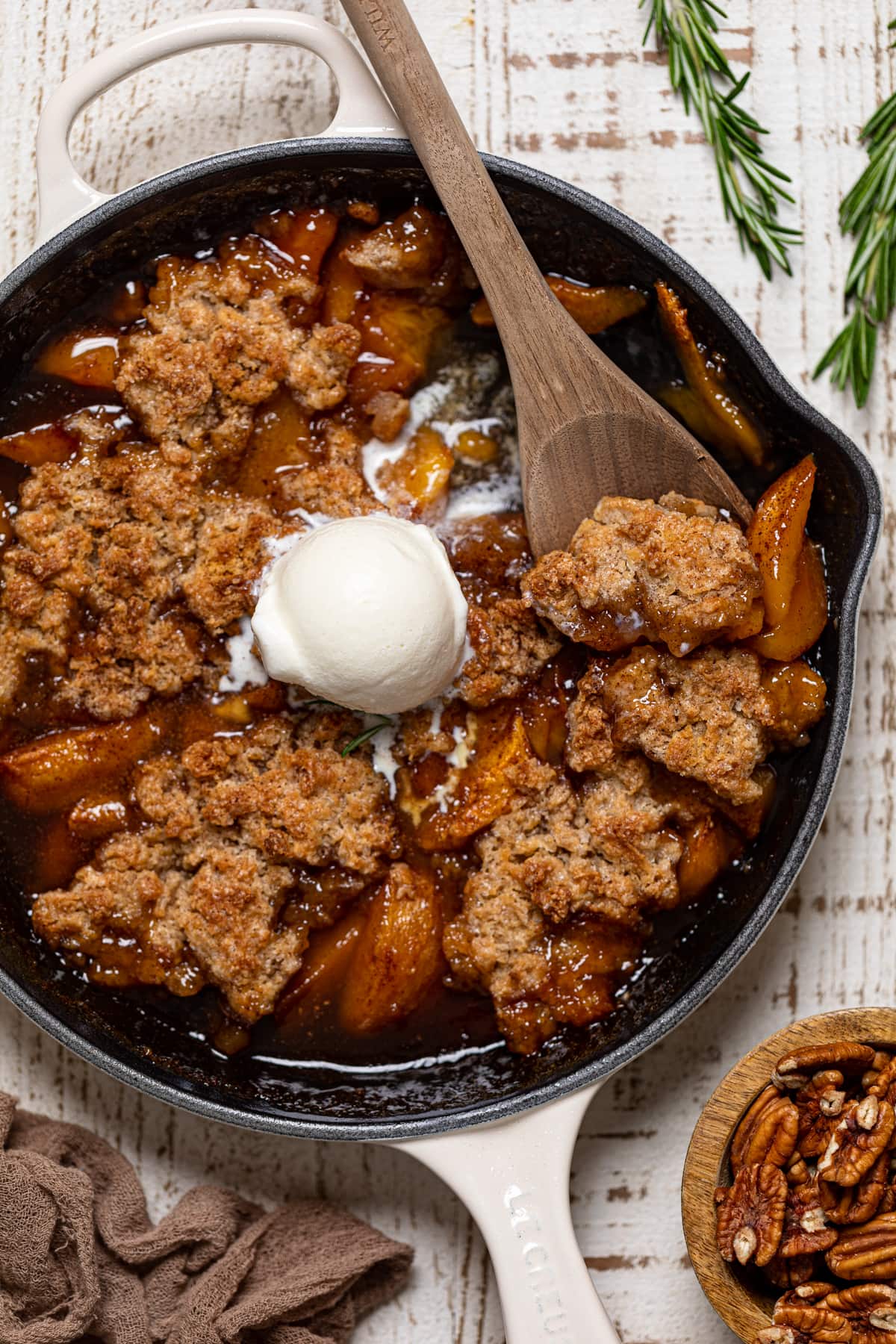 Wooden spoon scooping Vegan Southern Peach Cobbler.