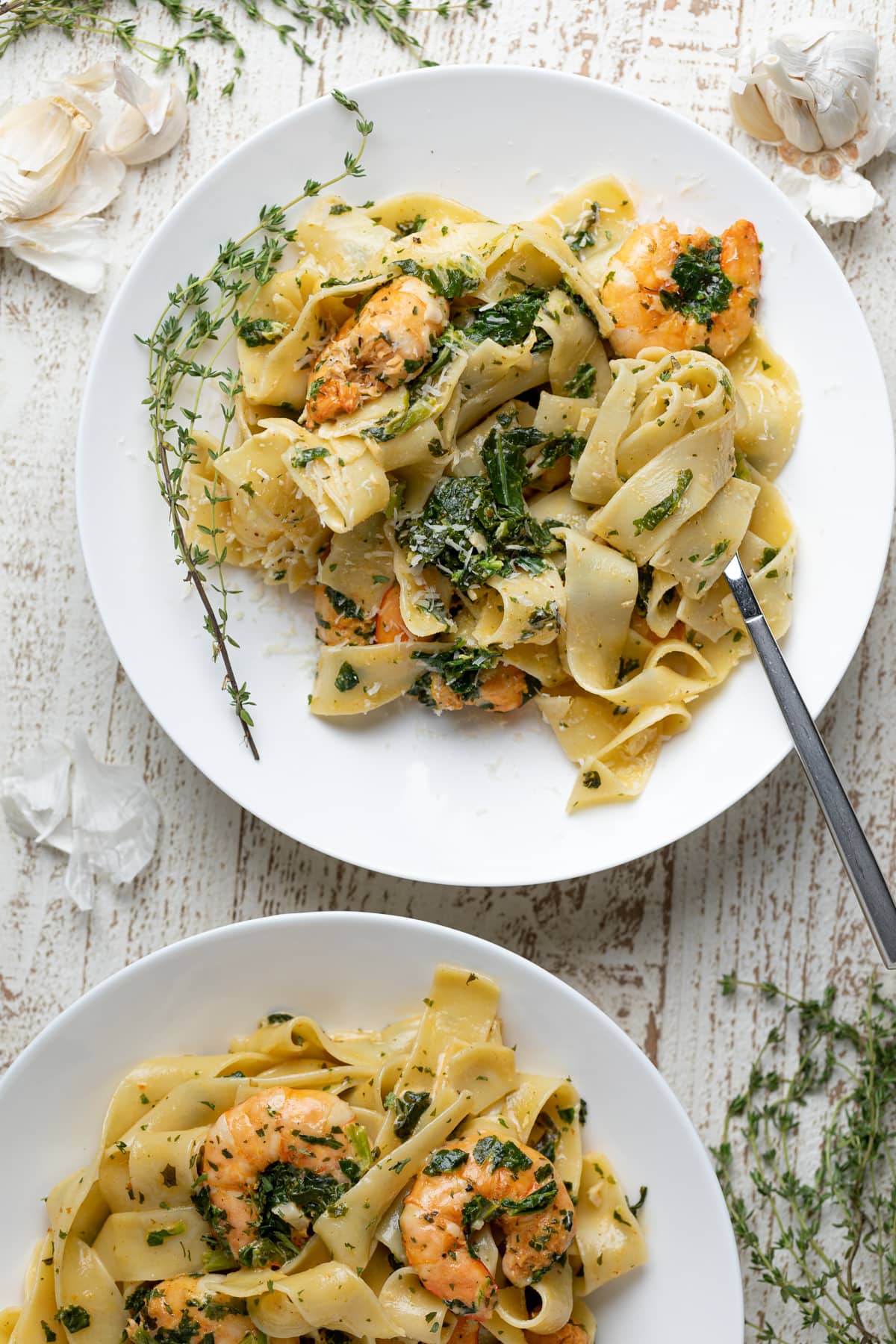 Two white plates of Savory Lemon Garlic Shrimp Pasta.