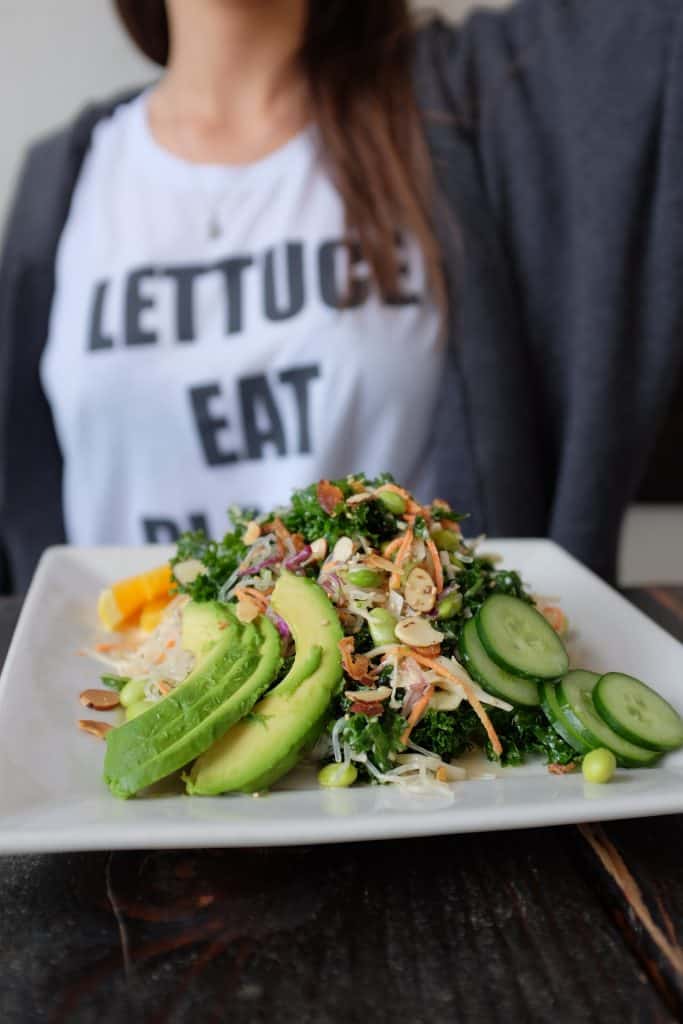 Person holding a plate of vegetables.