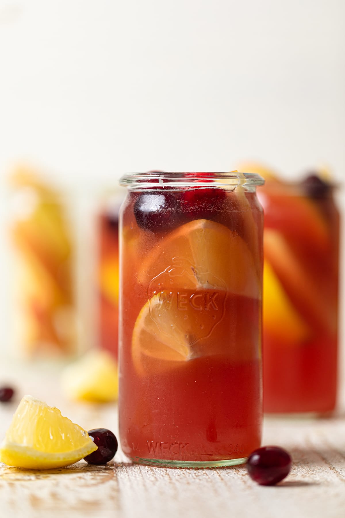 Apple Cranberry Ginger Lemon Detox Juice with cranberries and lemon slices.