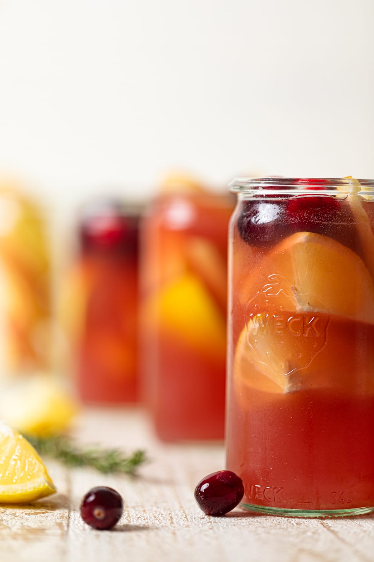 Line of tall glasses of Apple Cranberry Ginger Lemon Detox Juice.