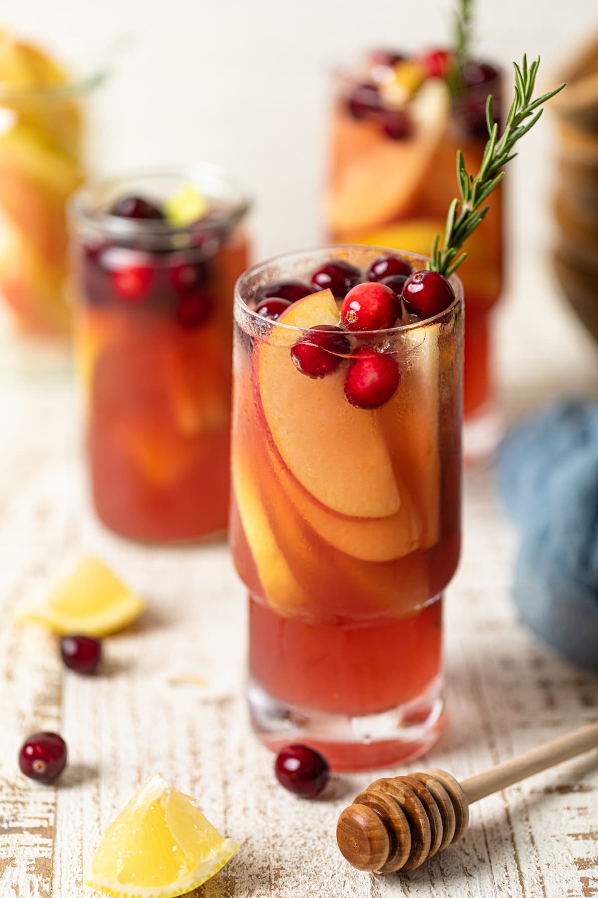 Several glasses of Apple Cranberry Ginger Lemon Detox Juice on a table.