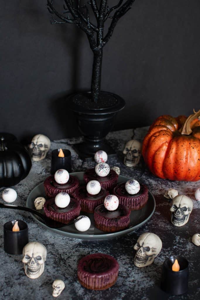 Halloween table with a plate of Halloween Graveyard Cheesecake Bites.