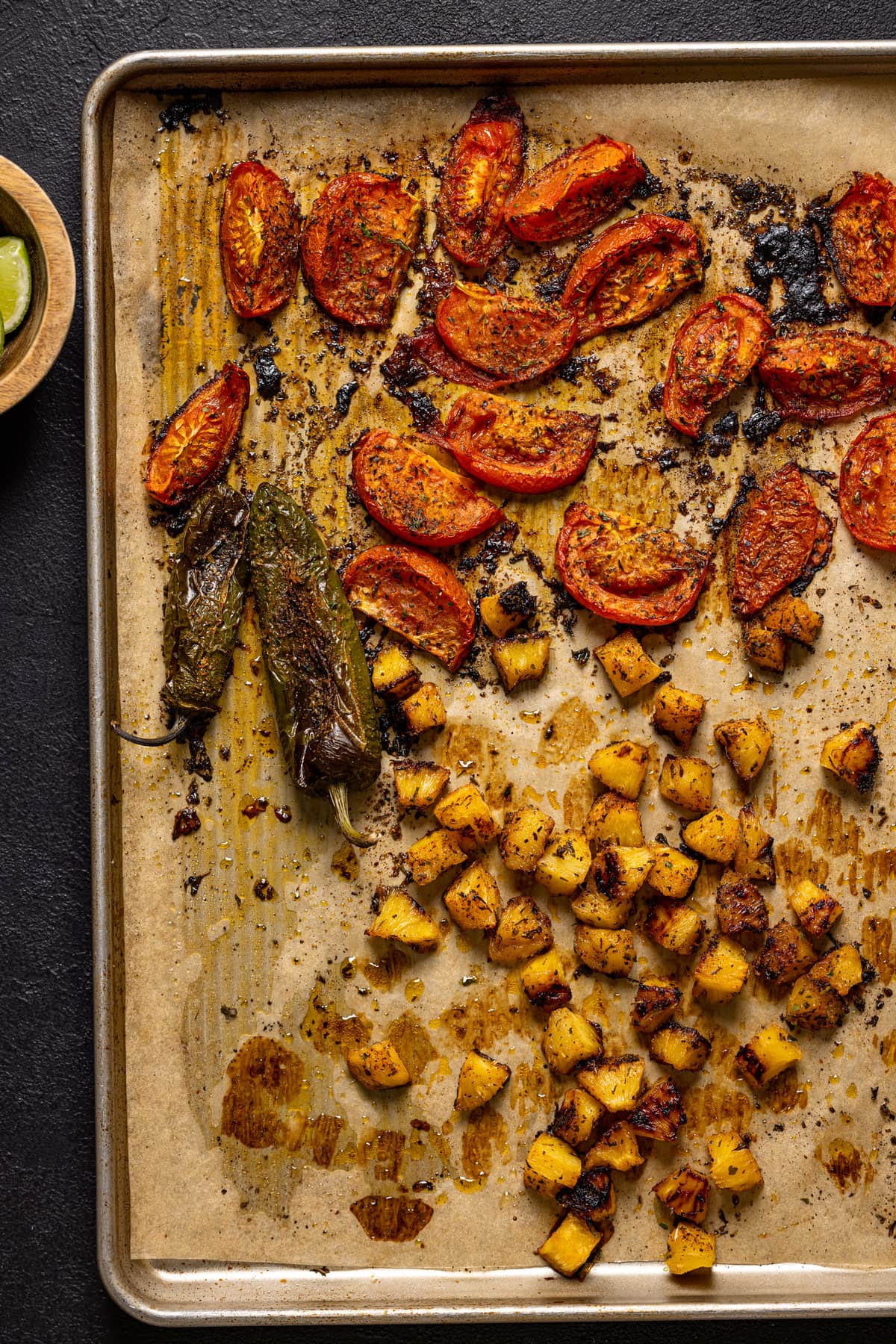 Sheet pan of roasted produce including peppers and tomato
