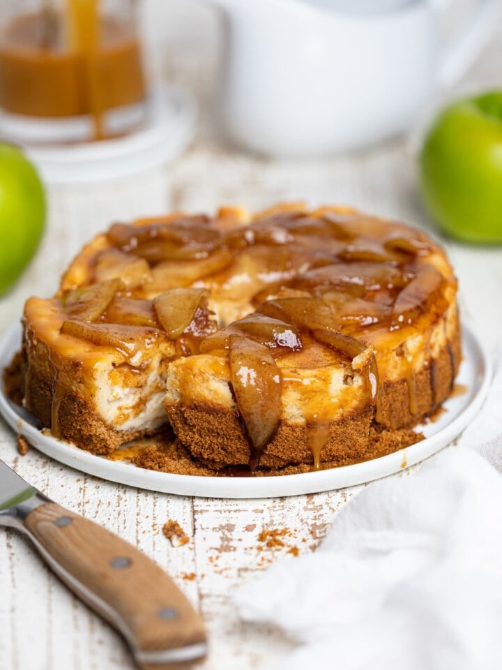 Sliced Caramel Apple Spice Cheesecake on a white plate