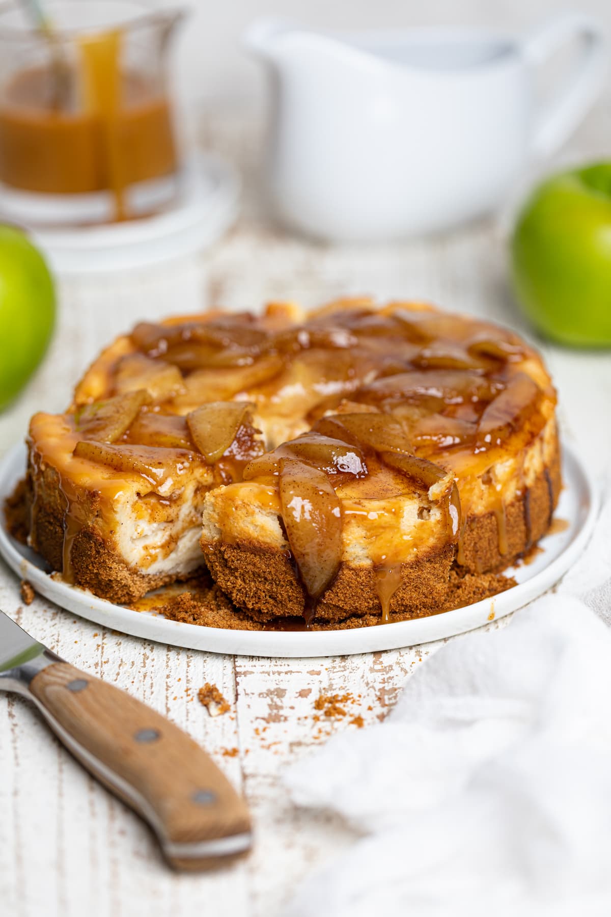 Sliced Caramel Apple Spice Cheesecake on a white plate