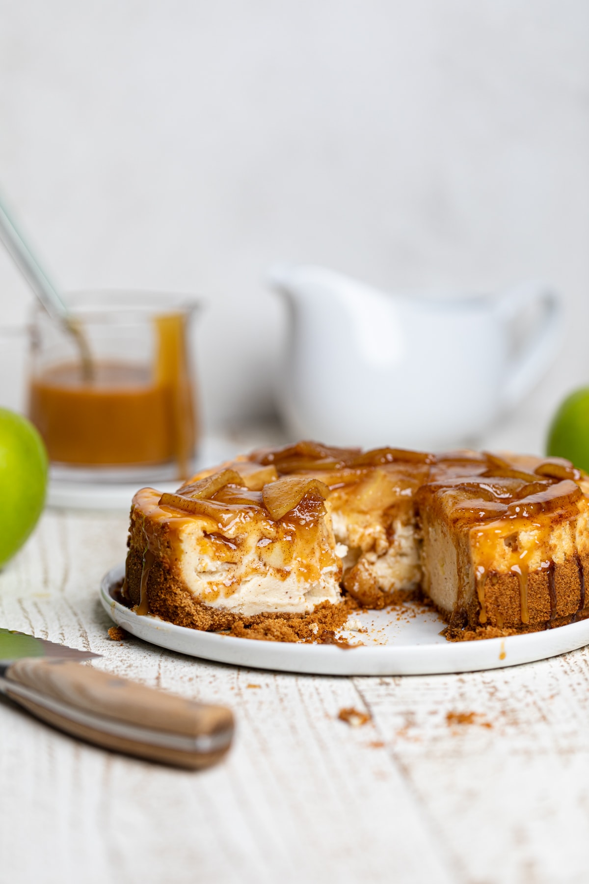 Caramel Apple Spice Cheesecake with a slice being removed.