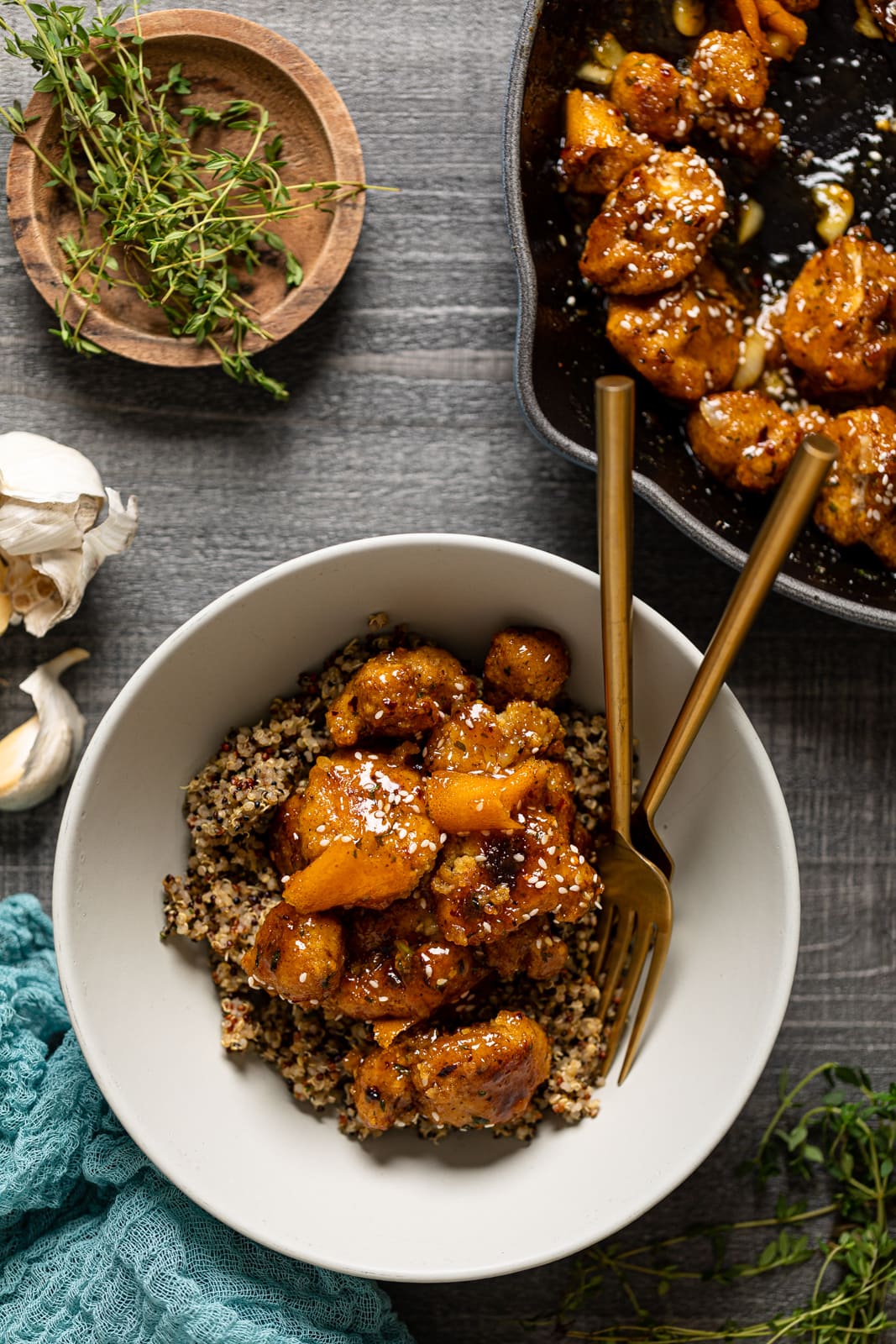Bowl and skillet of Baked Sticky Orange Cauliflower with Quinoa