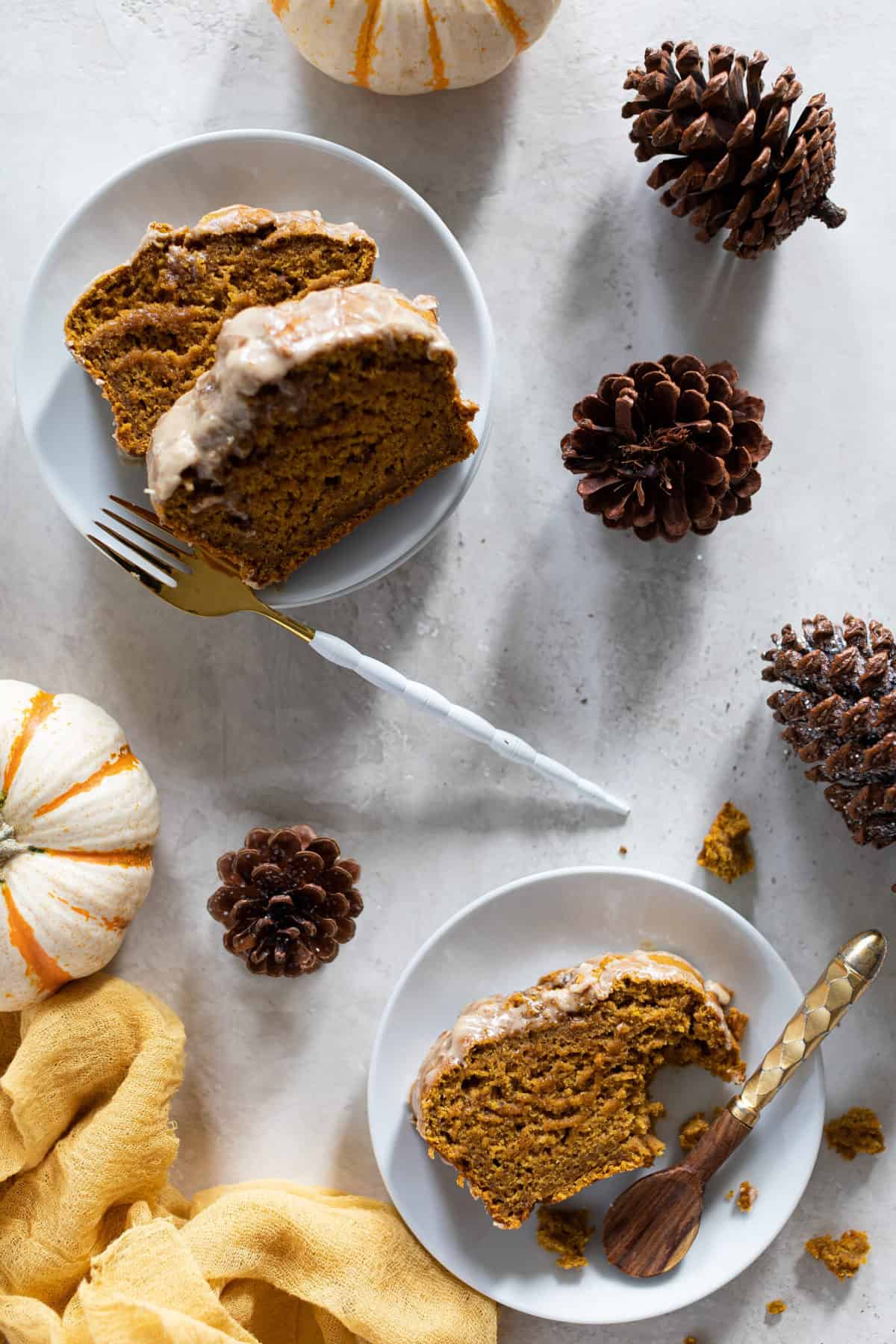 Slices of Vegan Pumpkin bread with Maple chai frosting on small plates.