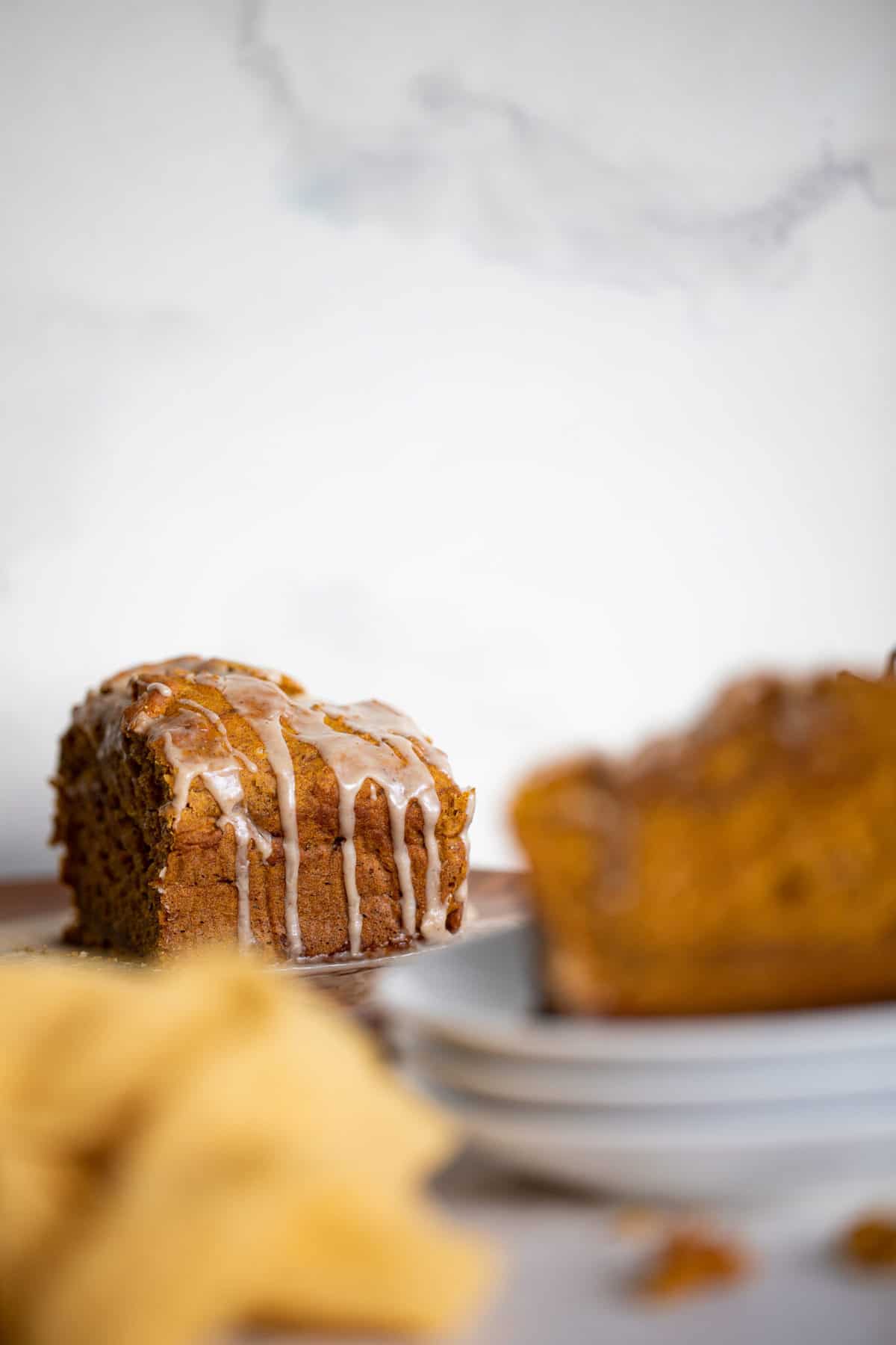 Half a loaf of Vegan Pumpkin Bread dripping with Maple Chai Frosting.