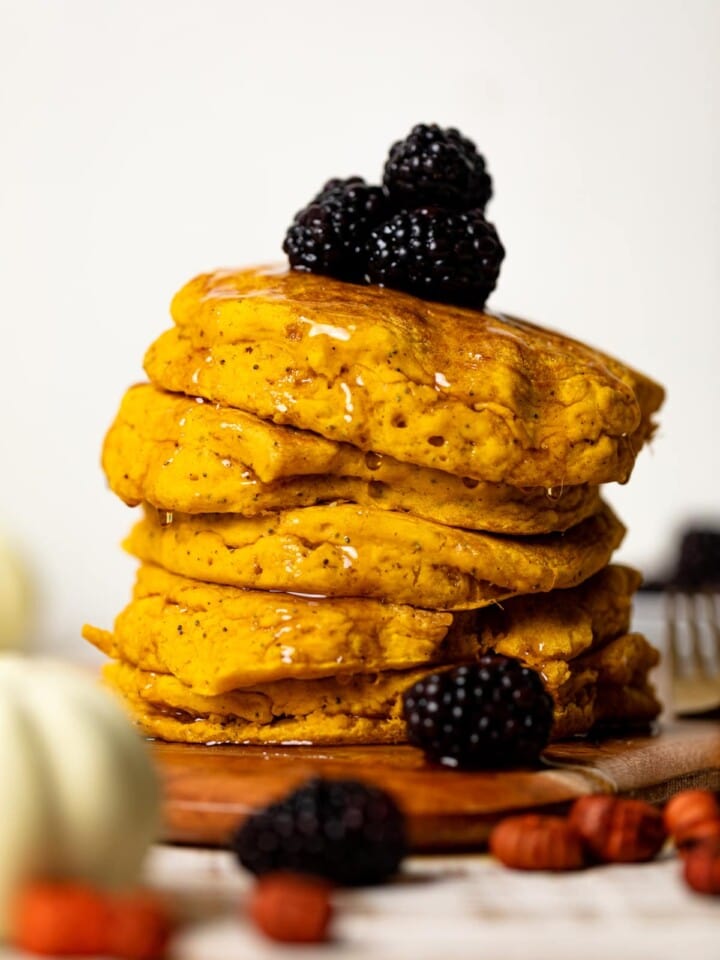 Stack of Vegan Pumpkin Poppyseed Pancakes on a wooden board