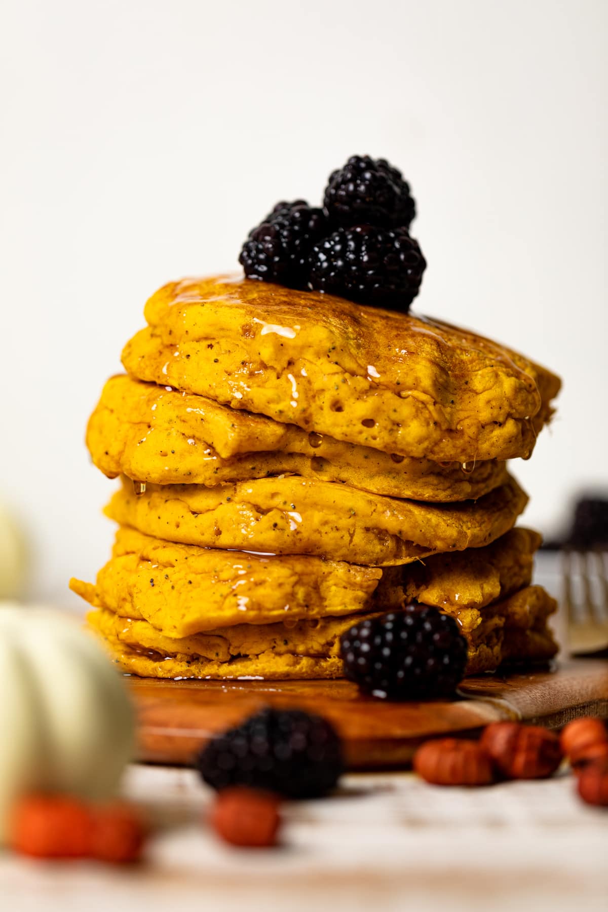 Stack of Vegan Pumpkin Poppyseed Pancakes on a wooden board