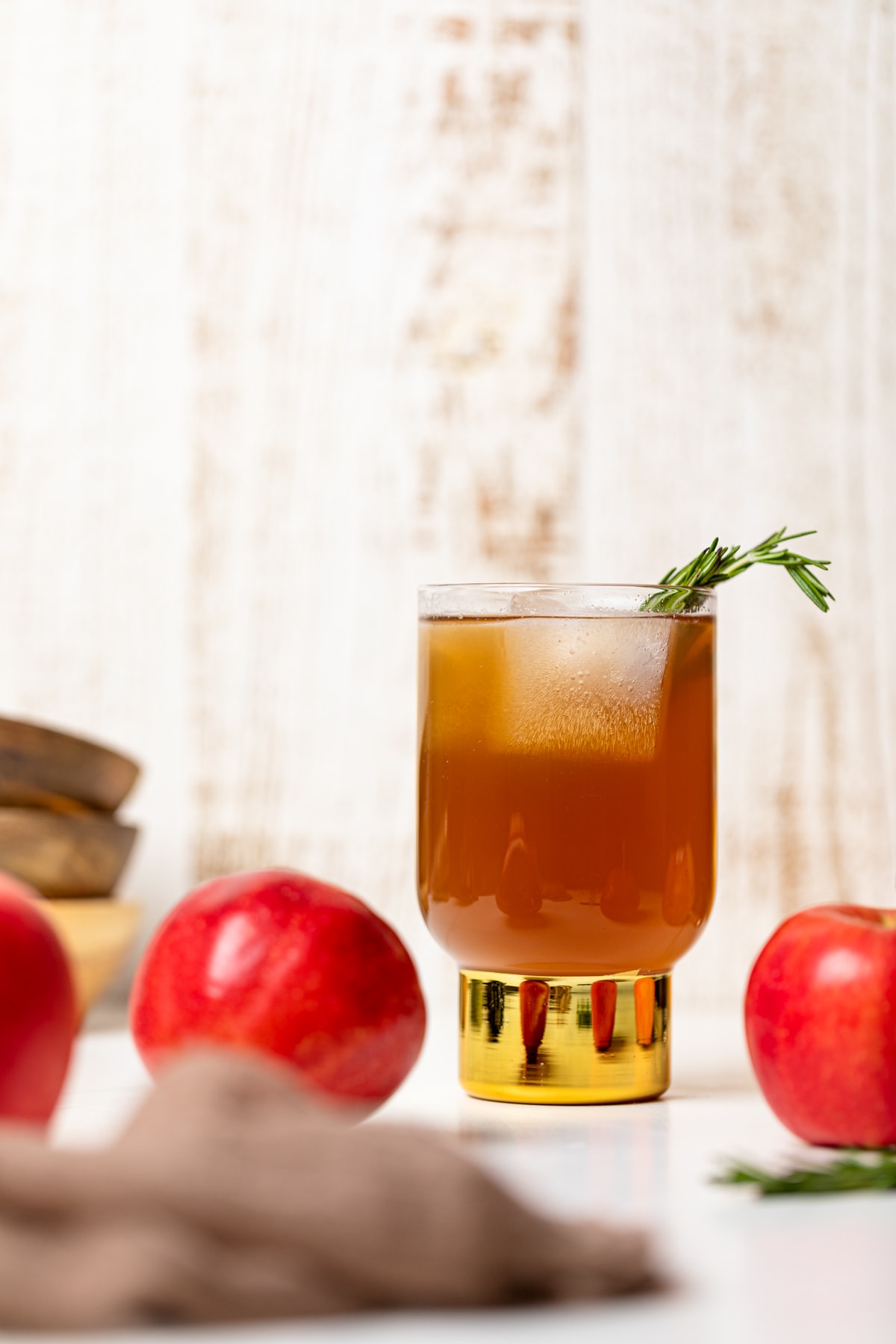 Glass of Homemade Slow Cooker Apple Cider with a sprig of rosemary.