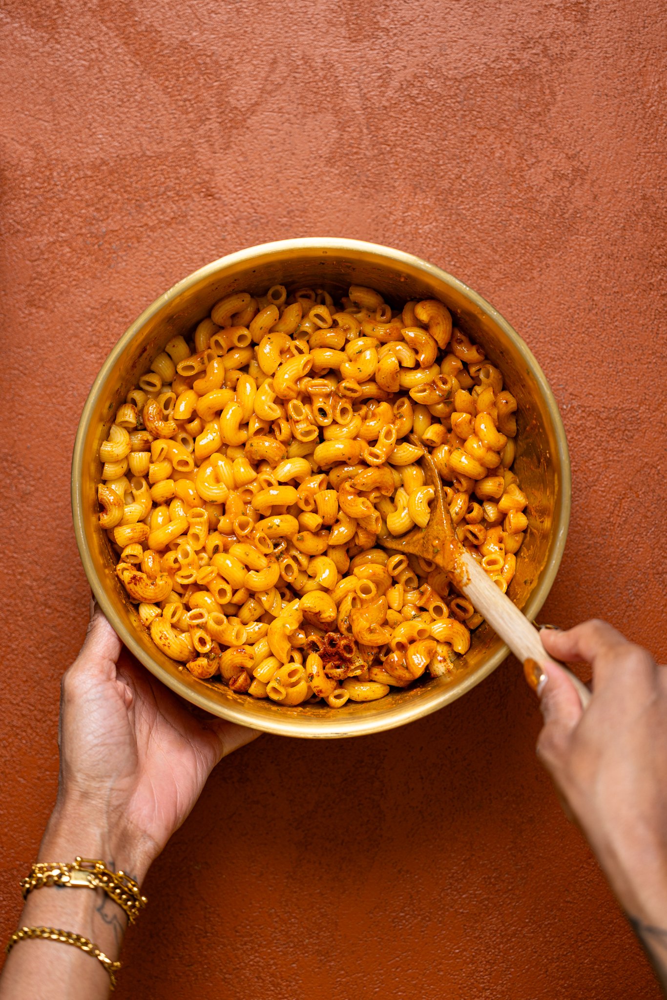 Ingredients in a bowl being stirred together with a wooden spoon.