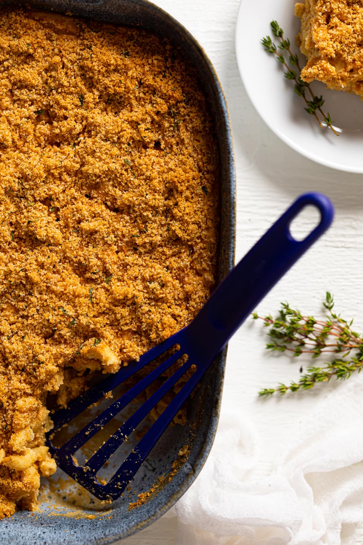 Blue spatula in a dish of Baked Vegan Buffalo Mac and Cheese.