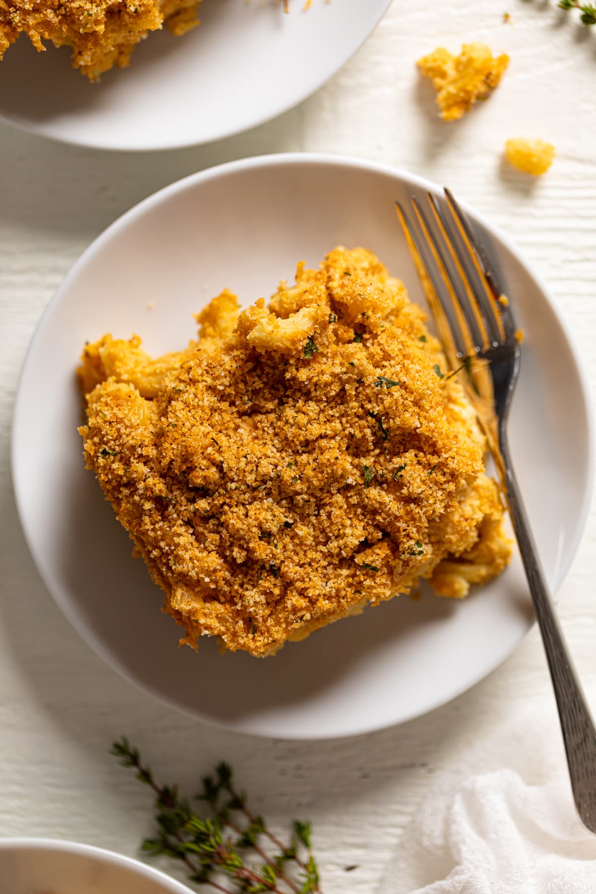 Slice of Baked Vegan Buffalo Mac and Cheese on a plate with a fork.