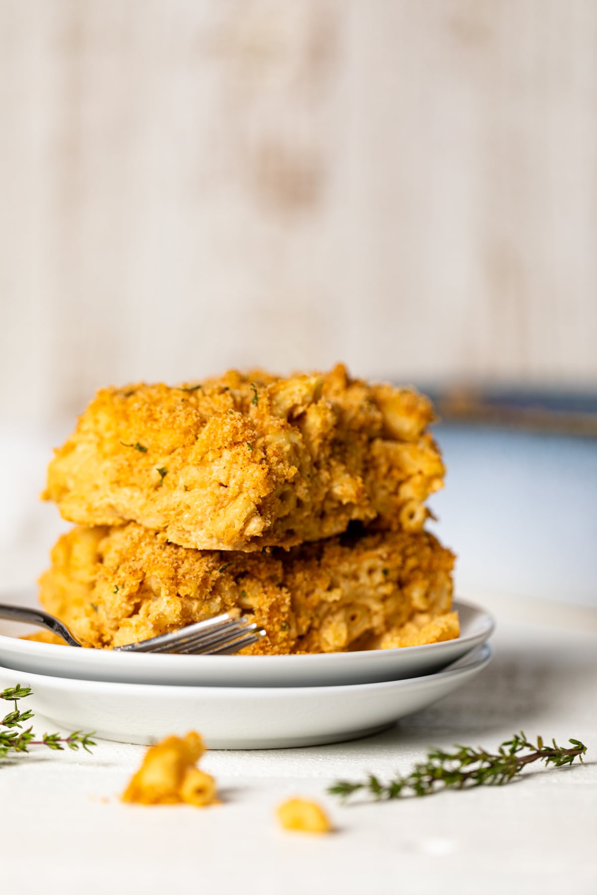 Pieces of Baked Vegan Buffalo Mac and Cheese on two small, stacked plates