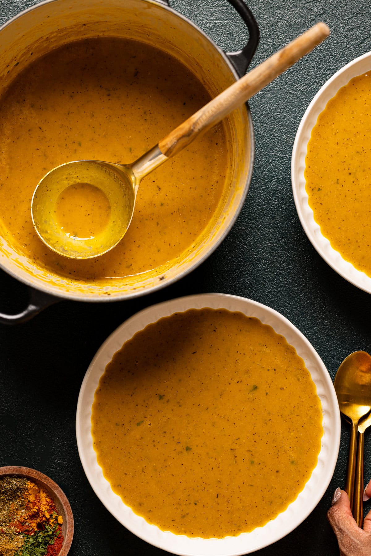 Ladle serving Roasted Butternut Squash Soup into two bowls