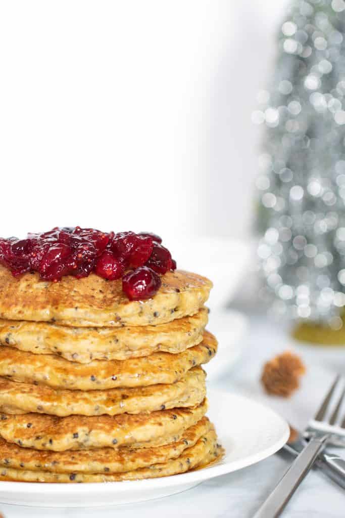 Tall stack of Vegan Quinoa Pancakes topped with Cranberries.
