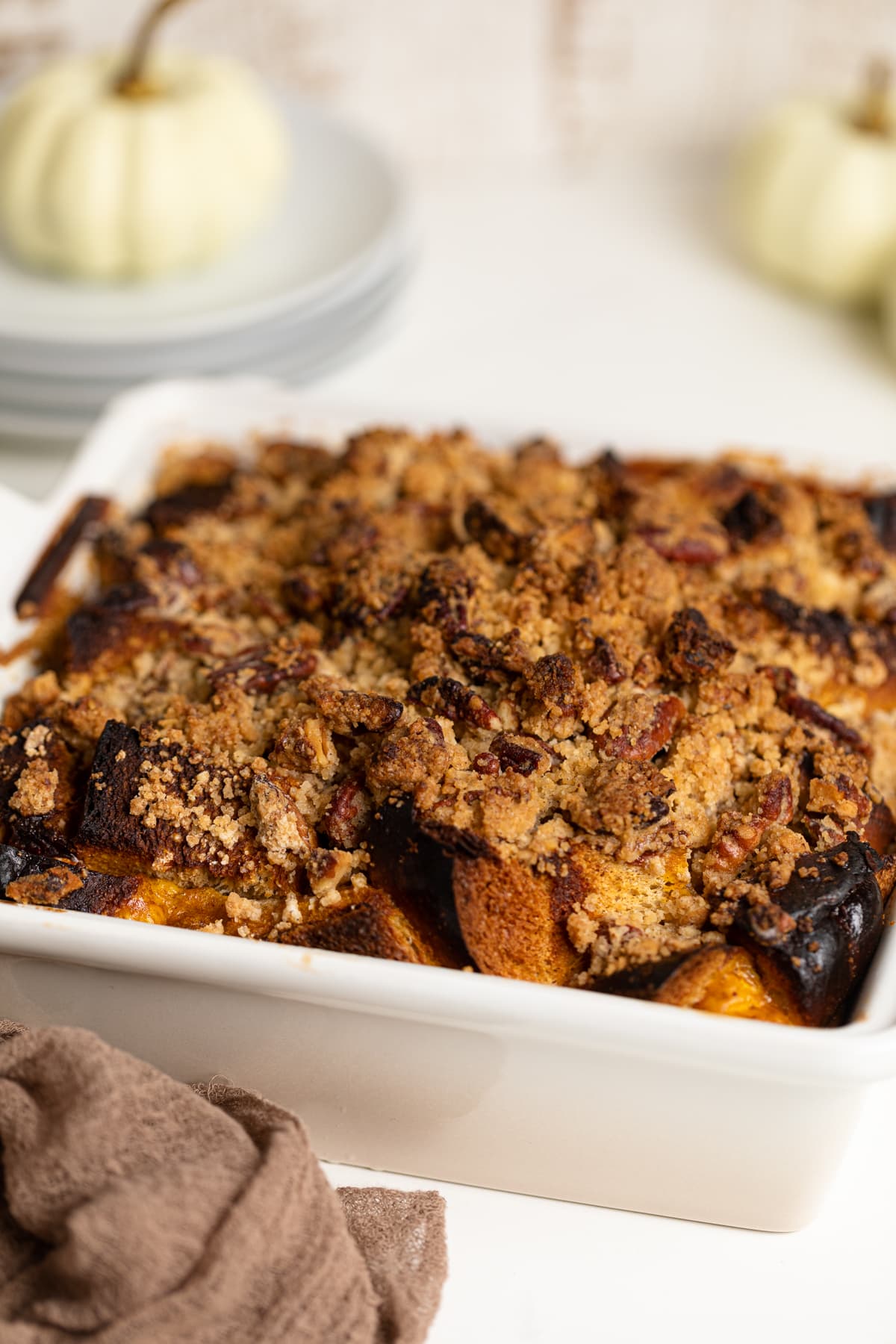 Baked Pumpkin French Toast Casserole in a white Le Creuset baking pan
