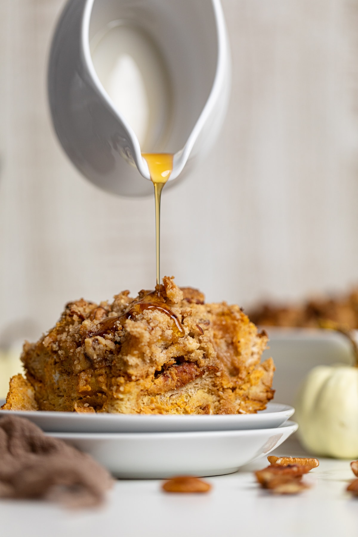 Maple syrup drizzling onto a piece of Baked Pumpkin French Toast Casserole