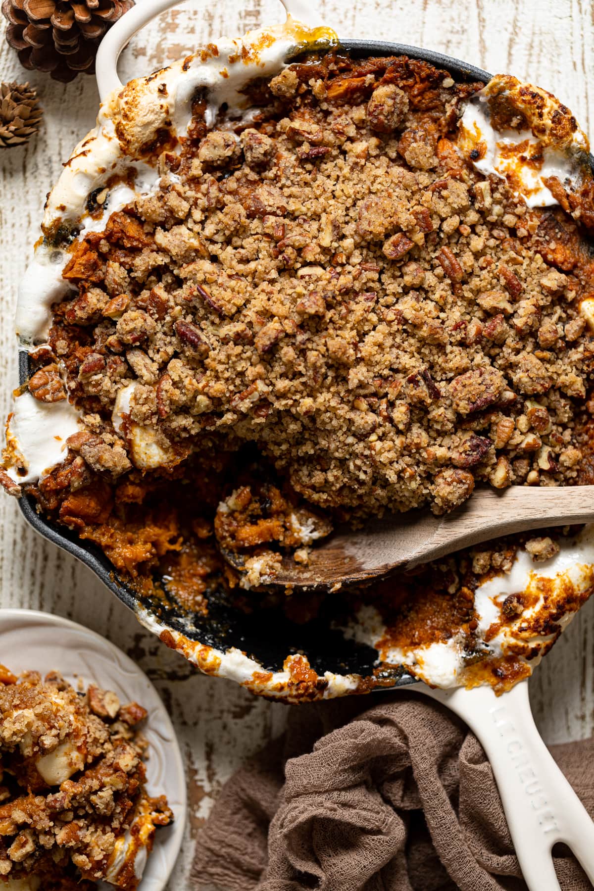 Wooden spoon scooping some Vegan Skillet Sweet Potato Casserole