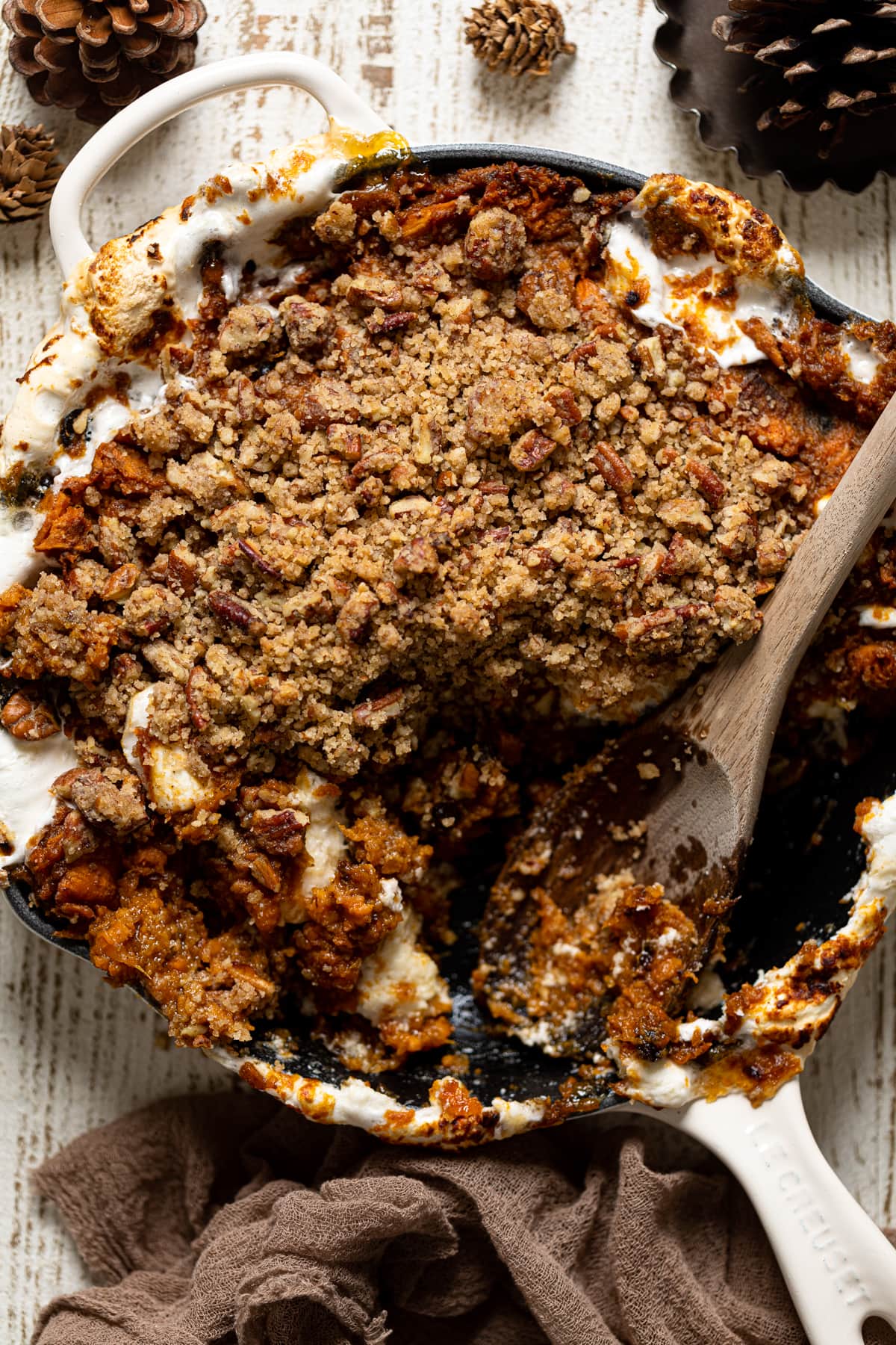 Wooden spoon in a skillet of Vegan Sweet Potato Casserole