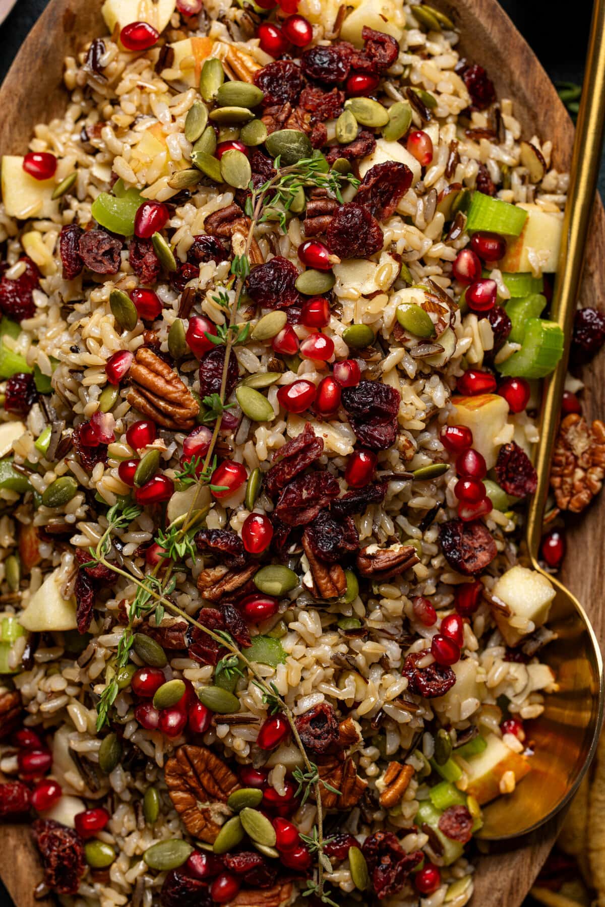 Up close shot of wild rice stuffing with gold serving spoon.