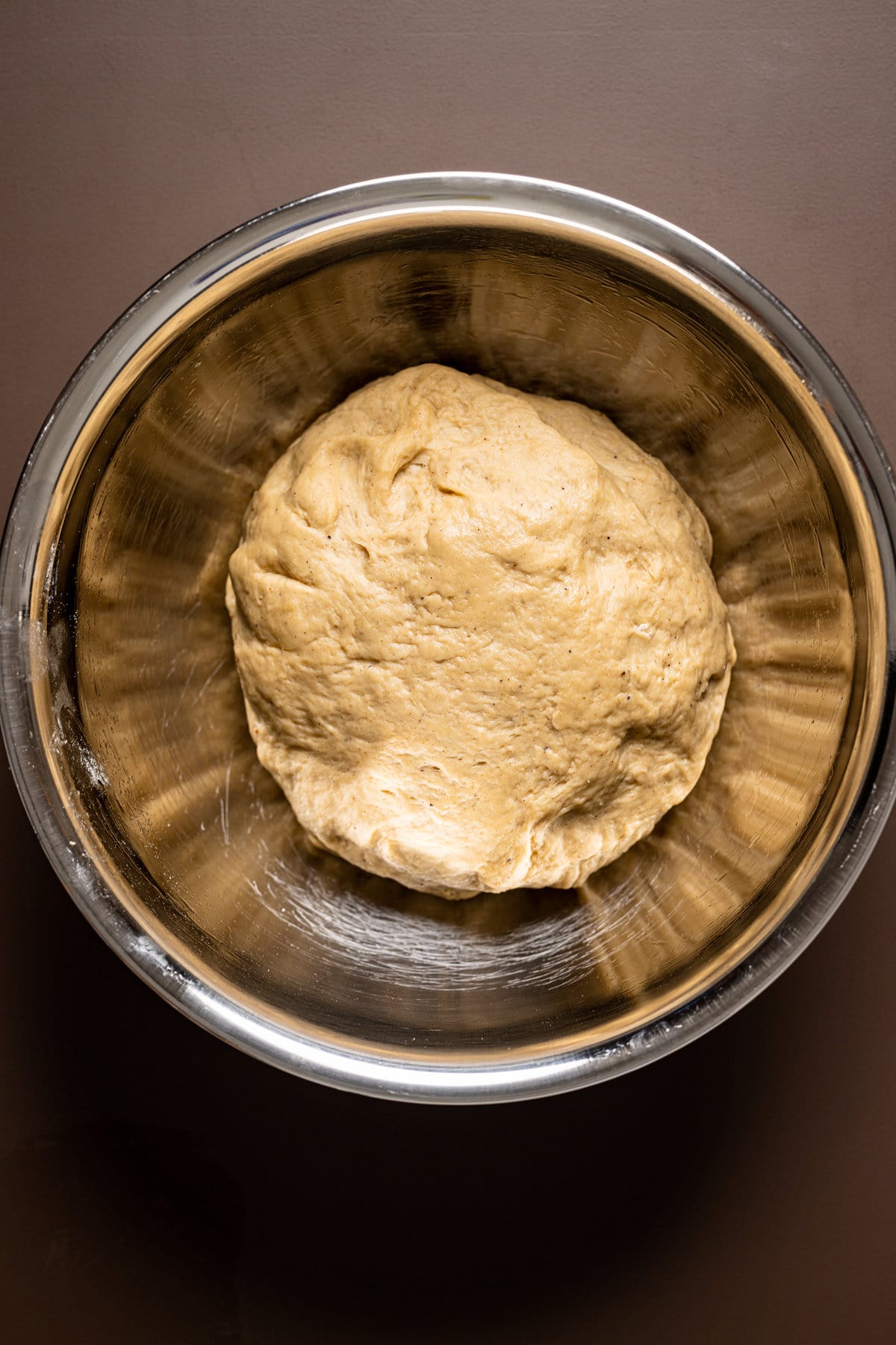 Ball of Vegan Chai Latte Cinnamon Roll dough in a bowl