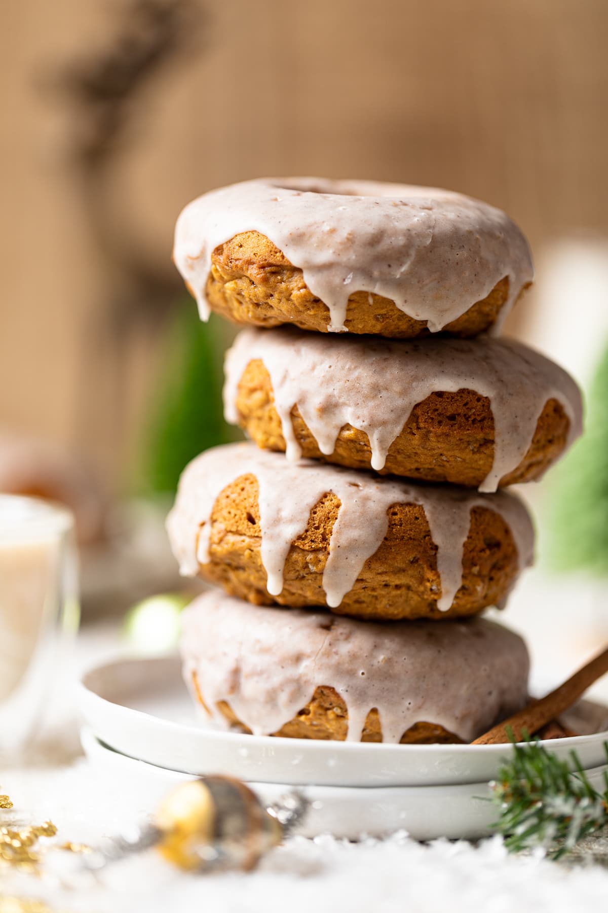 Vegan Gingerbread Donuts with Chai Glaze stacked on a white plate.