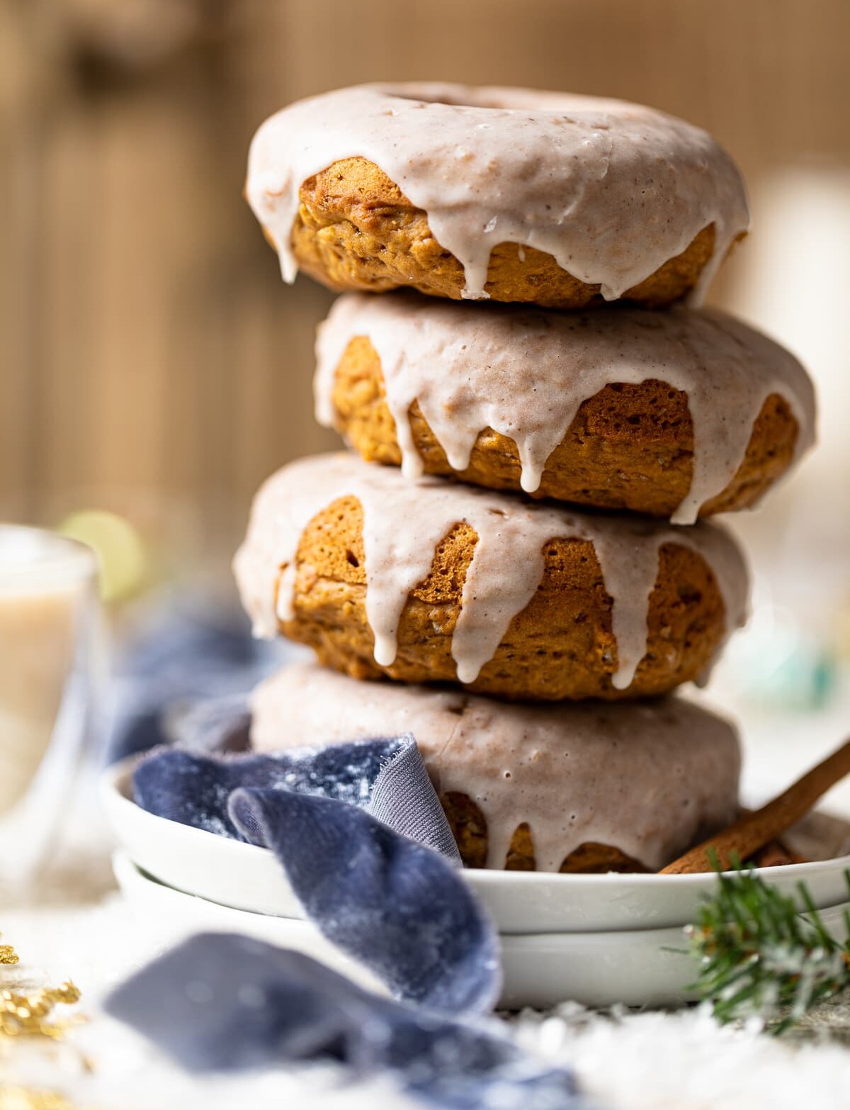 Vegan Gingerbread Donuts with Chai Glaze stacked on white plates.