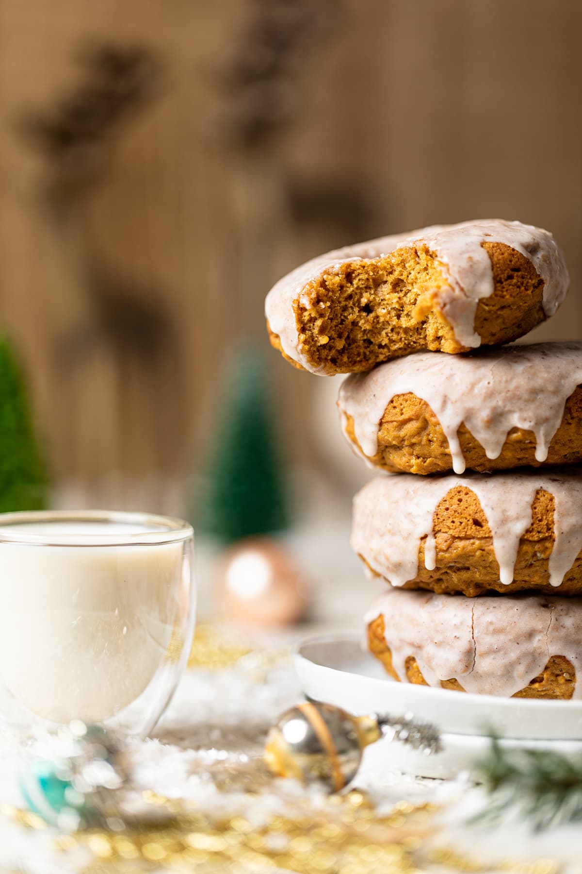 Stacked Vegan Gingerbread Donuts with Chai Glaze, the top of which is missing a bite.