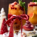 Red bow tied around a Honey Grapefruit Holiday Mocktail