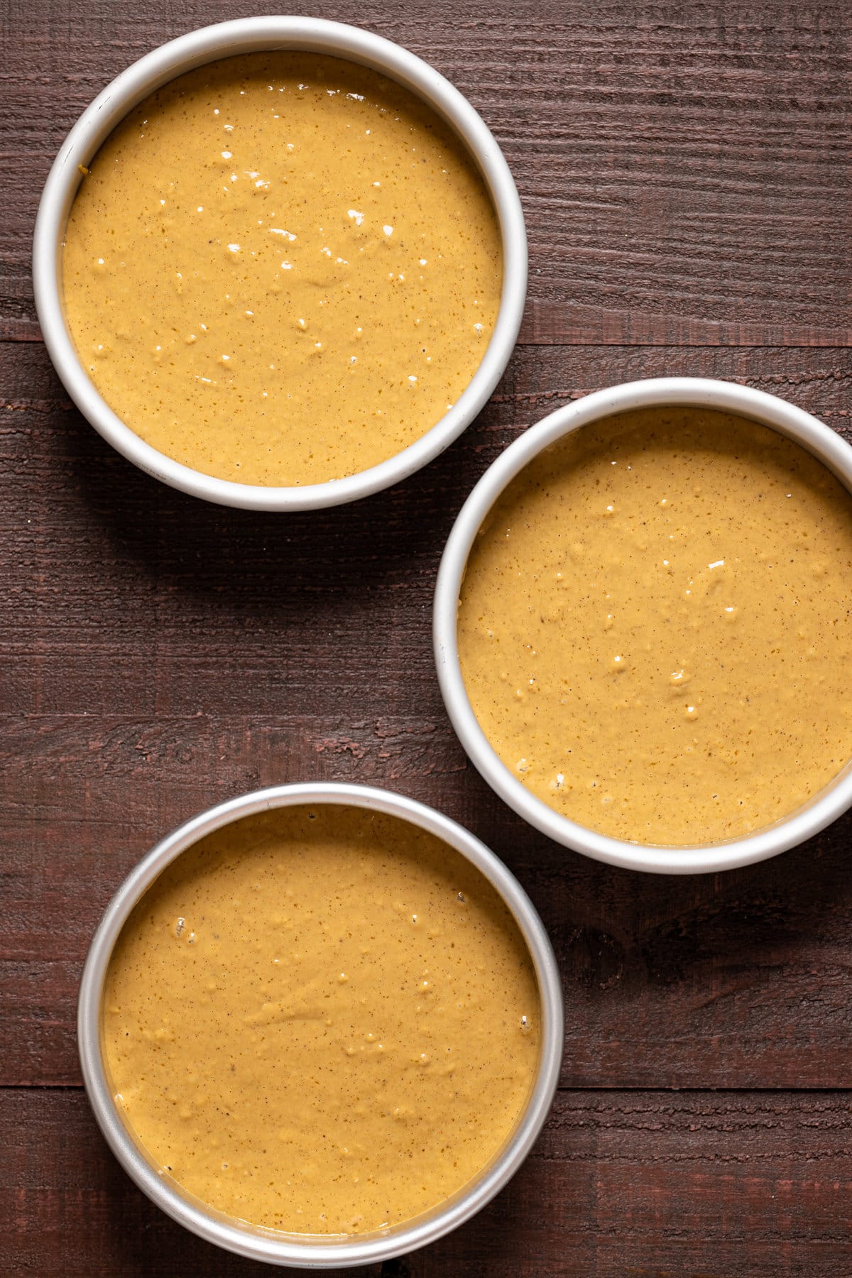 Three round pans of Vegan Gingerbread Cake batter