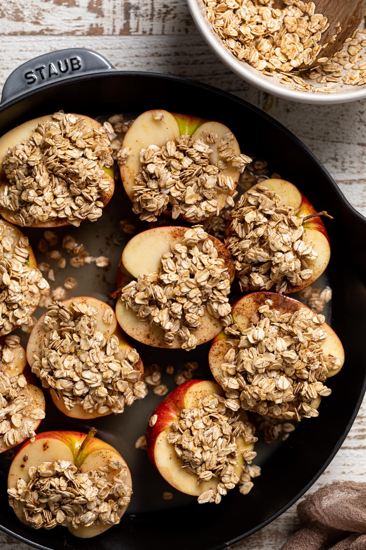Skillet of halved apples topped with spiced oats.