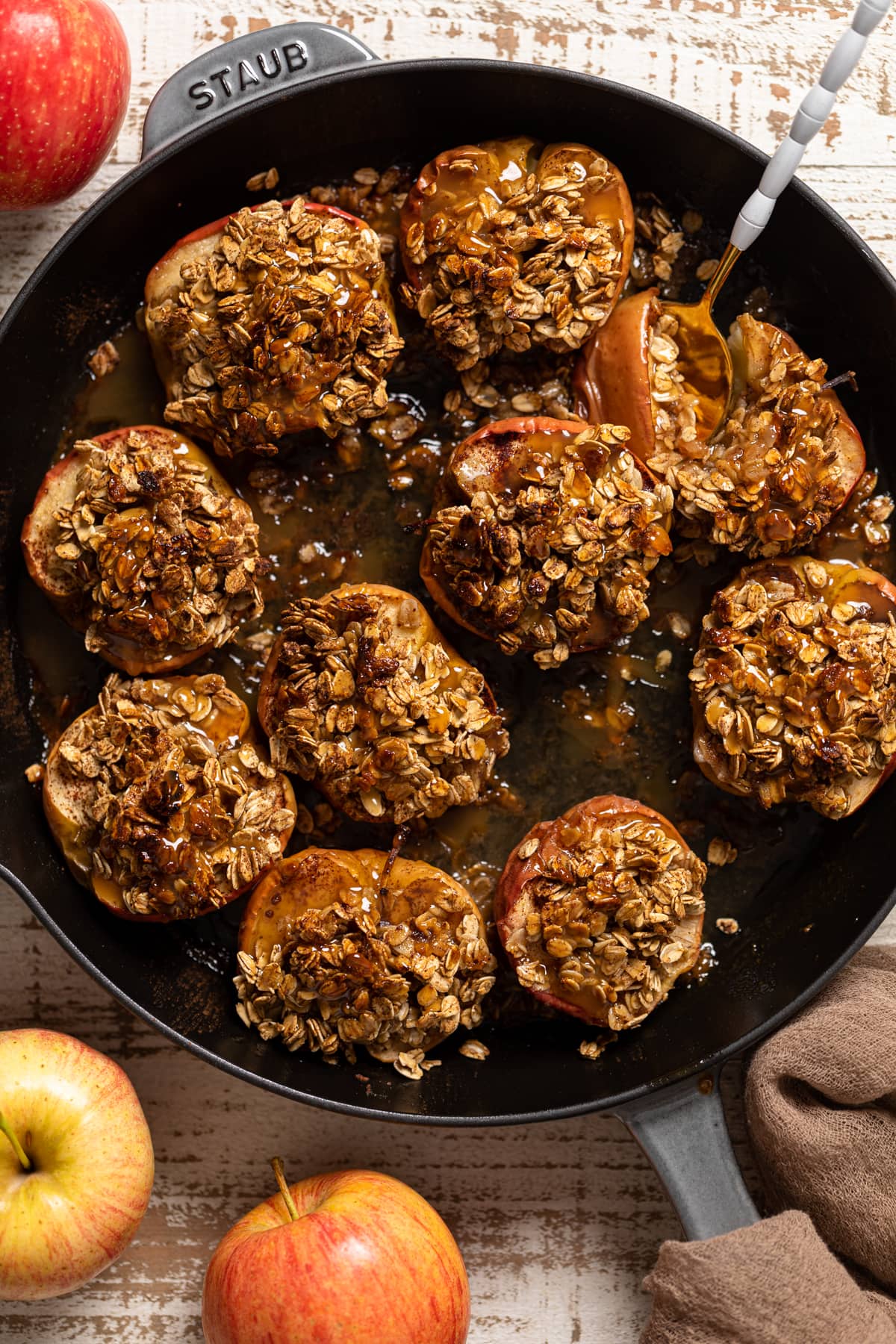 Spoon scooping Vegan Baked Cinnamon Caramel Apples from a skillet.