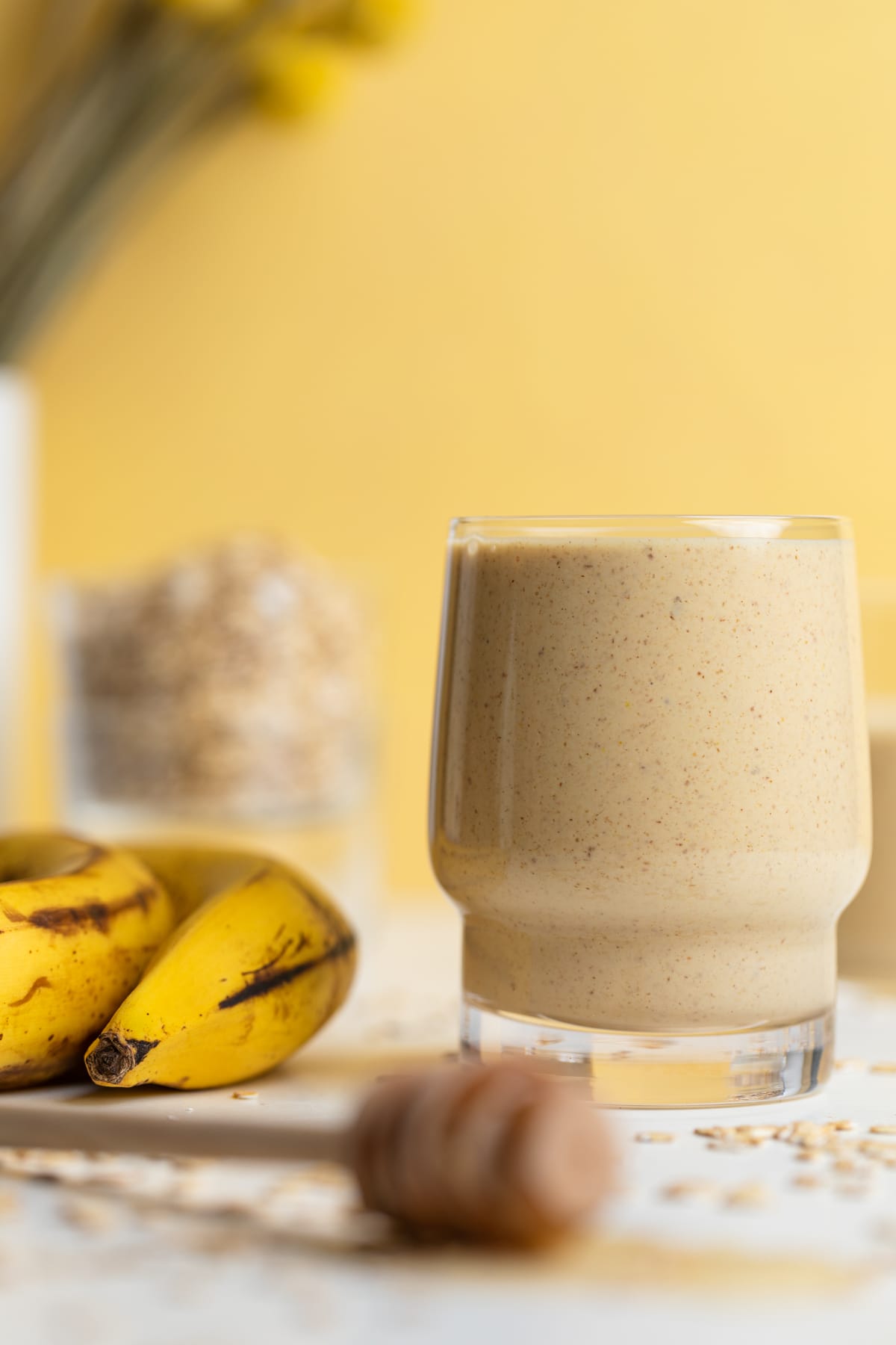 Peanut Butter Banana Oats Smoothie next to some bananas.
