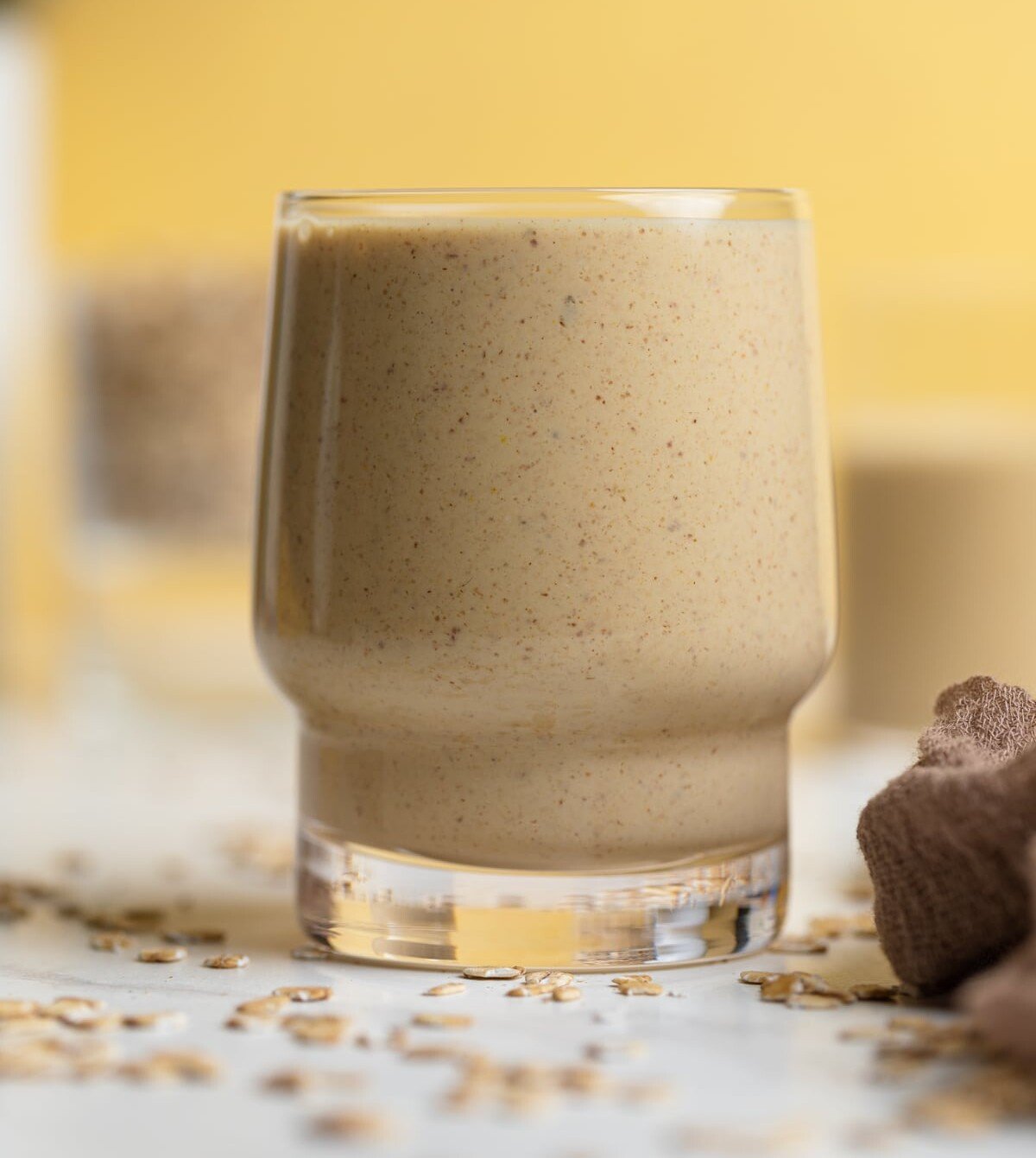 Peanut Butter Banana Oats Smoothie on a table with oats.