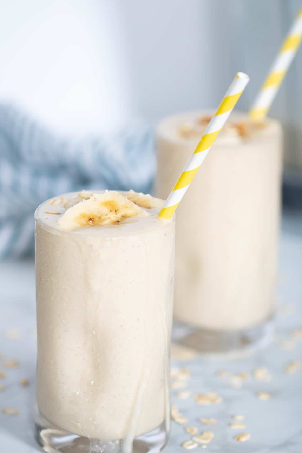 Two Peanut Butter Banana Oats Smoothies in tall glasses.