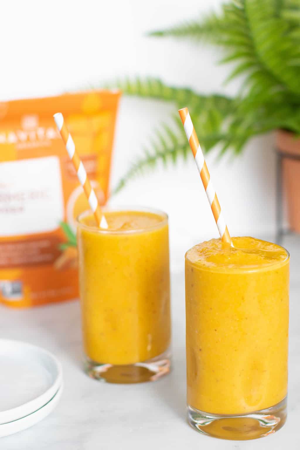 Two Turmeric \'Wake Up\' Smoothies with straws.