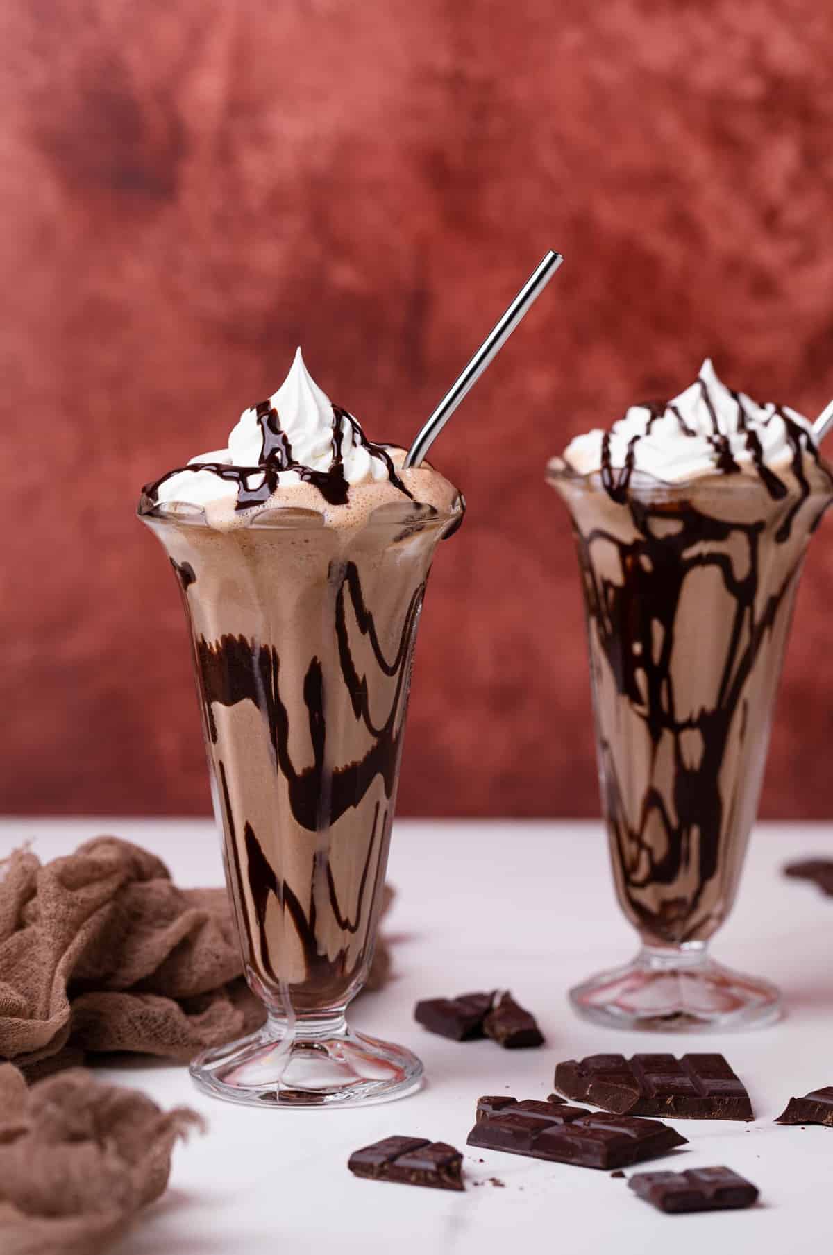 Two Dairy-Free Peanut Butter Chocolate Milkshakes in tall glasses.