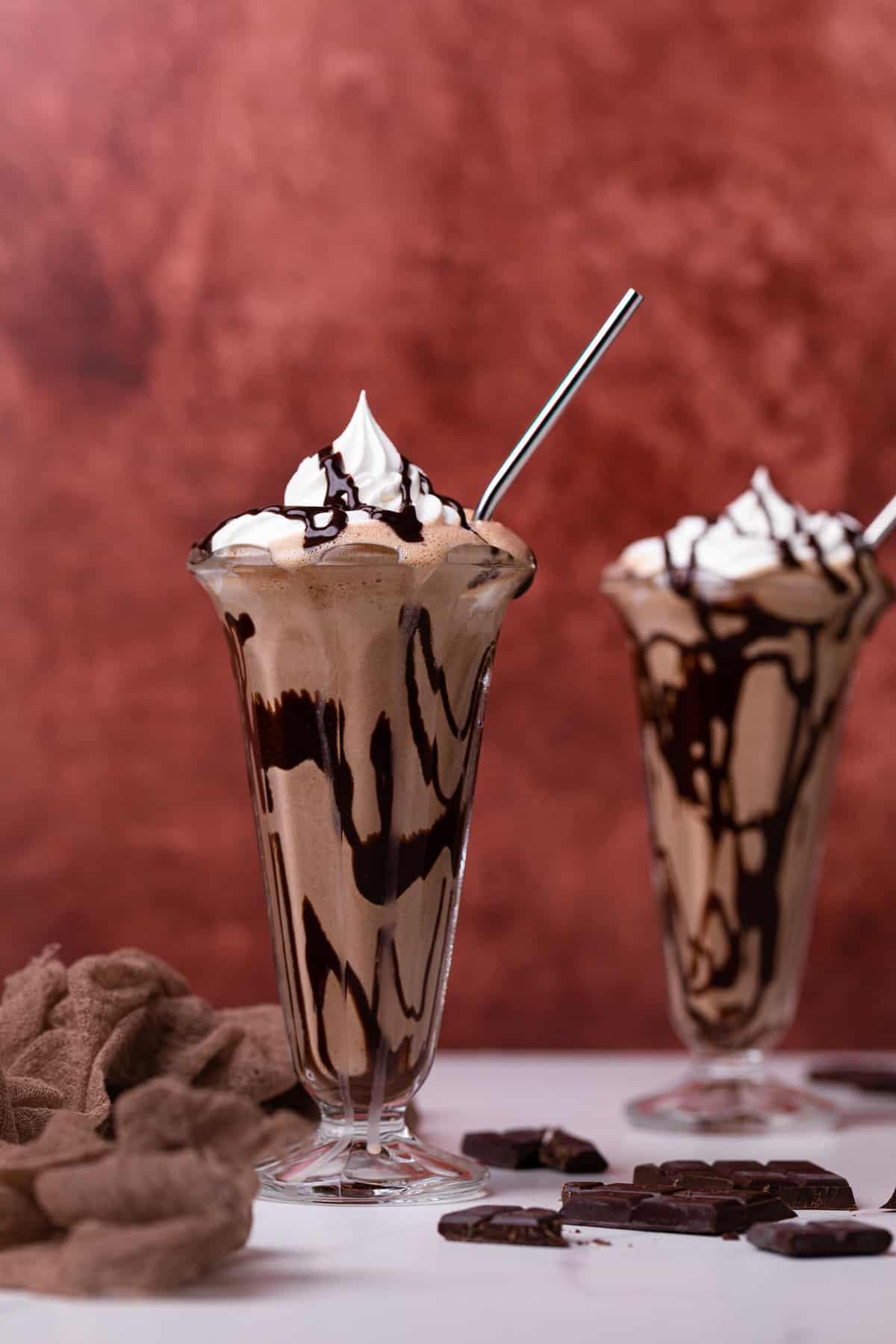 Two Dairy-Free Peanut Butter Chocolate Milkshakes in tall glasses with metal straws.