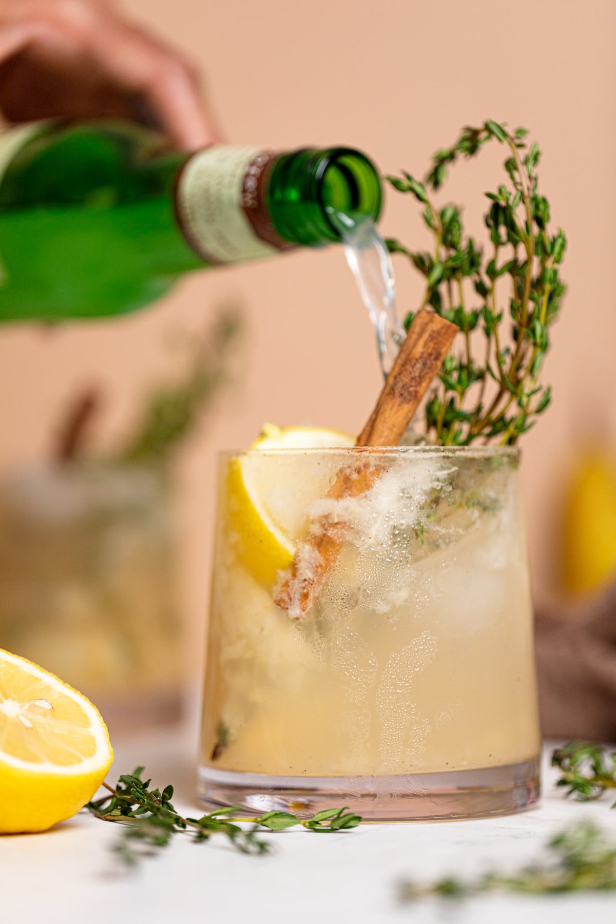 Ginger beer pouring into a Pear Ginger Lemon and Thyme Drink.