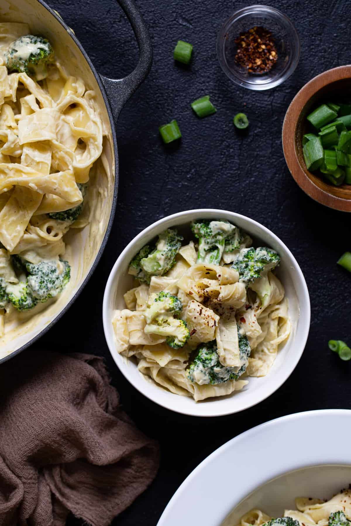 White bowl of vegan broccoli alfredo pasta.